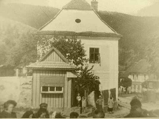 Snad žádné opravě budovy v Doubravníku nebyla věnována taková pozornost, jako záchraně "staré školy". Snímek z roku 1942. V popředí obchůdek - trafika.
